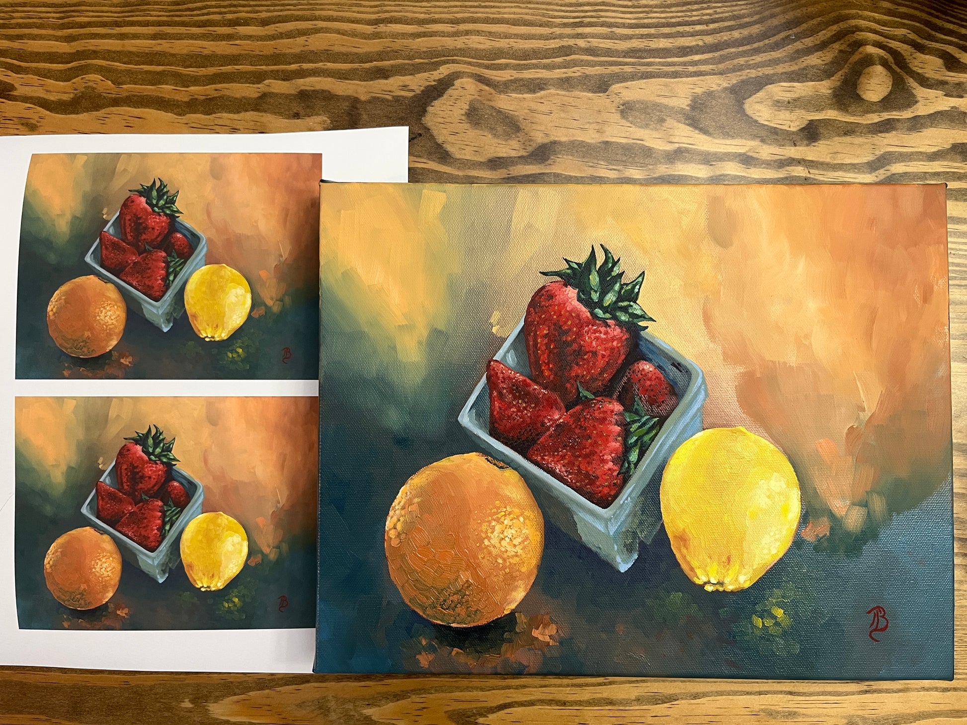 Original still life painting and fine art prints of strawberries, an orange and a lemon on a wooden surface.