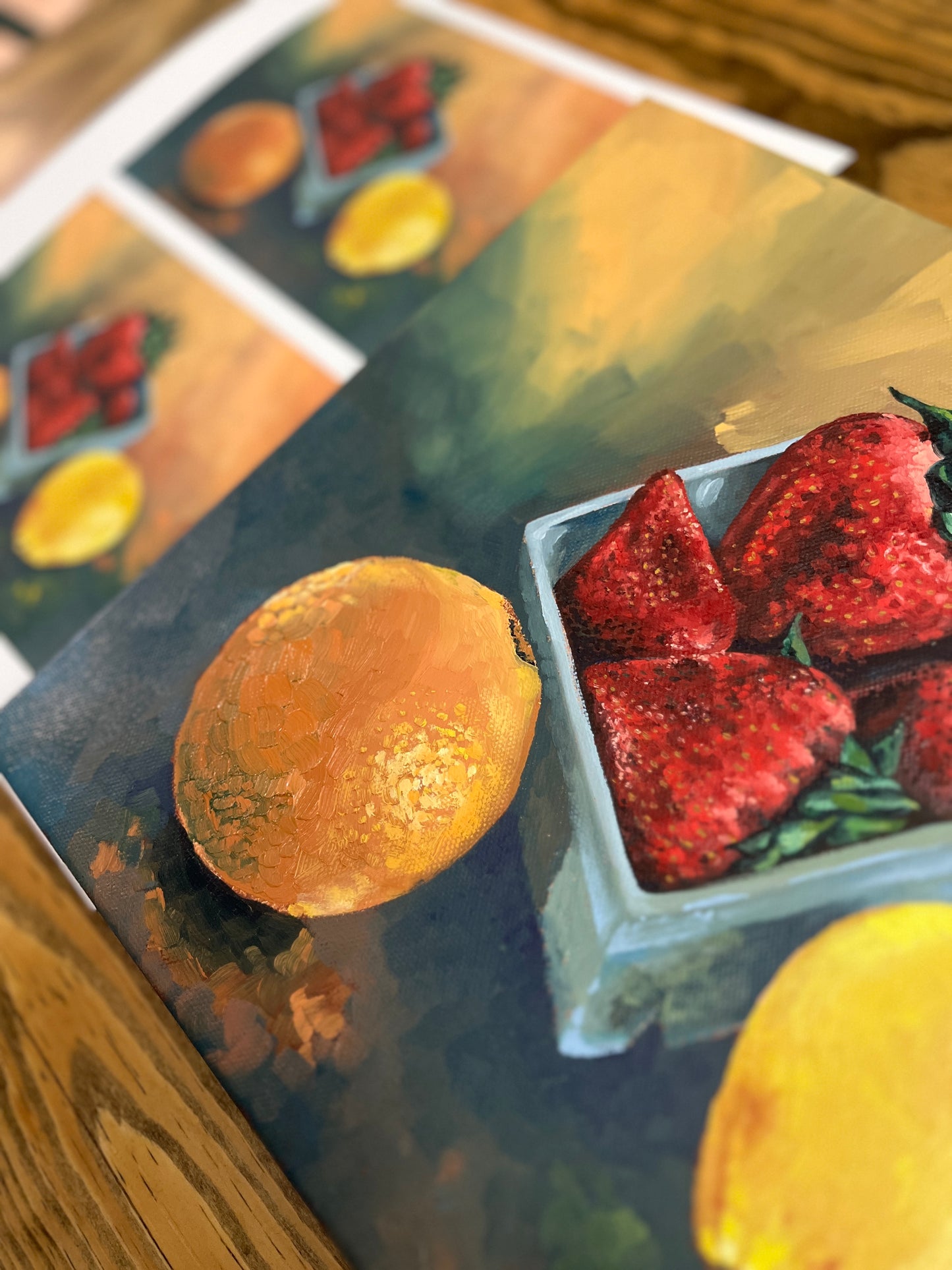 Original still life painting and fine art prints of strawberries, an orange and a lemon on a wooden surface.