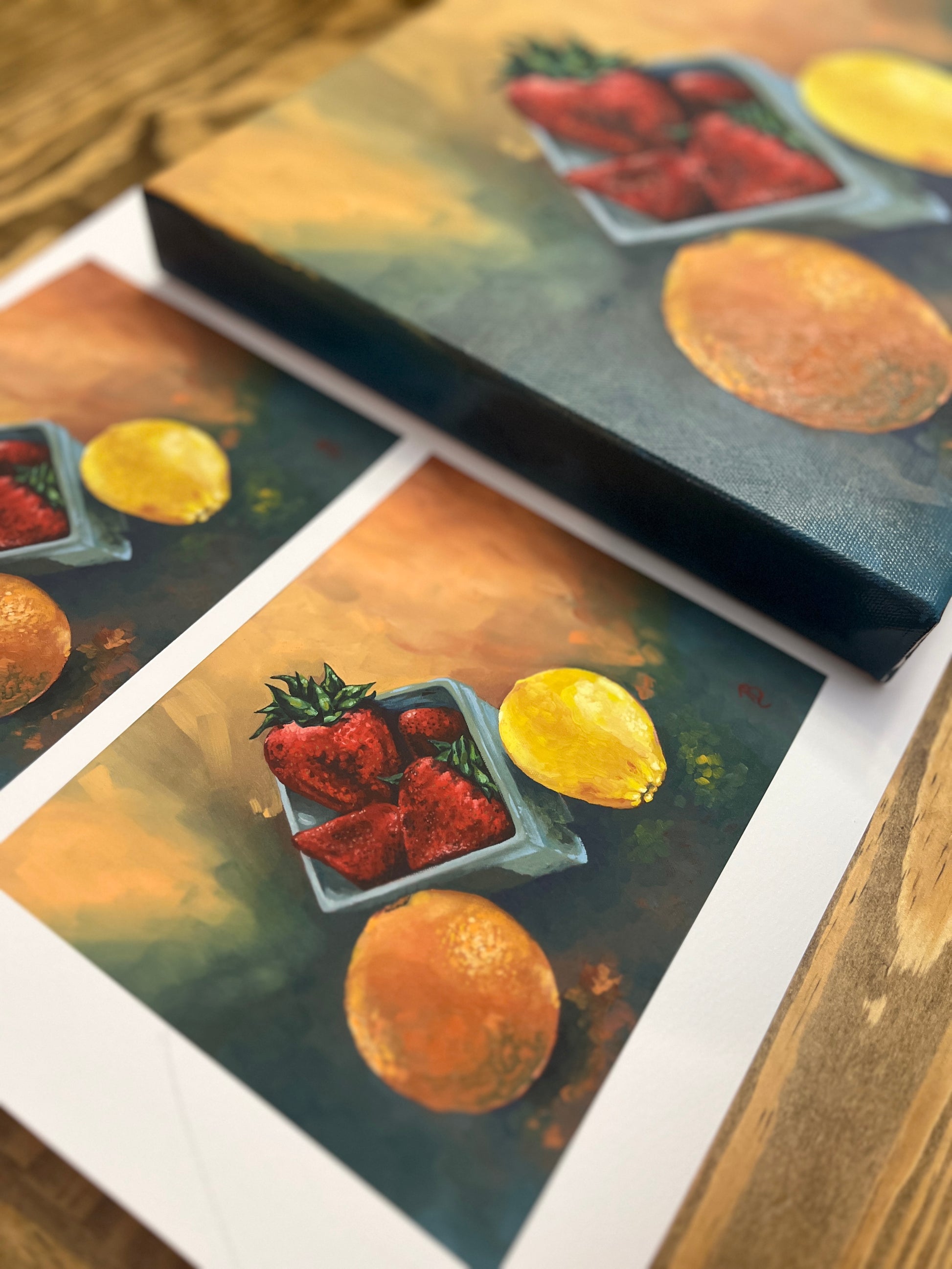Original still life painting and fine art prints of strawberries, an orange and a lemon on a wooden surface.