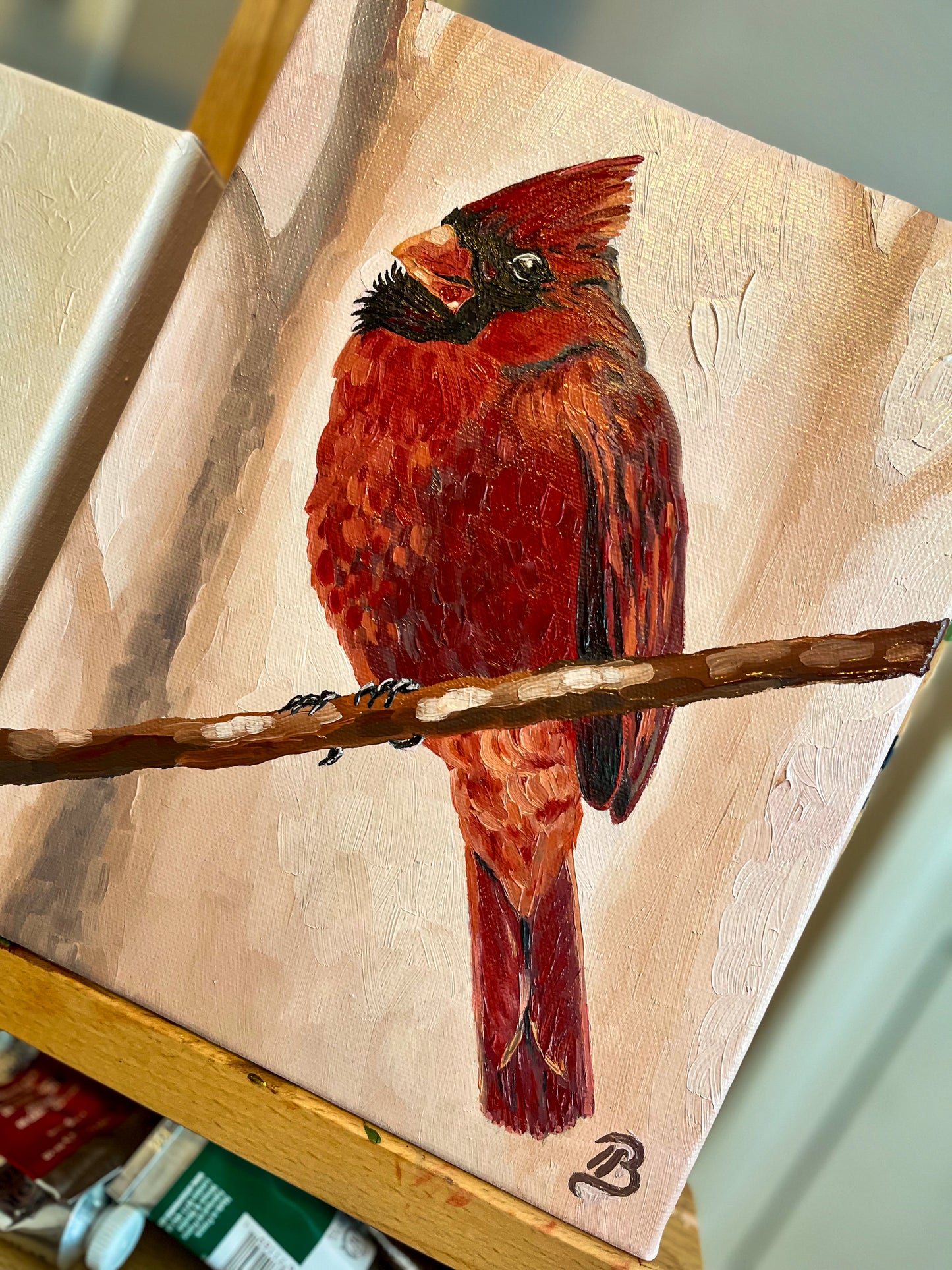 Red cardinal bird painting on a wooden easel
