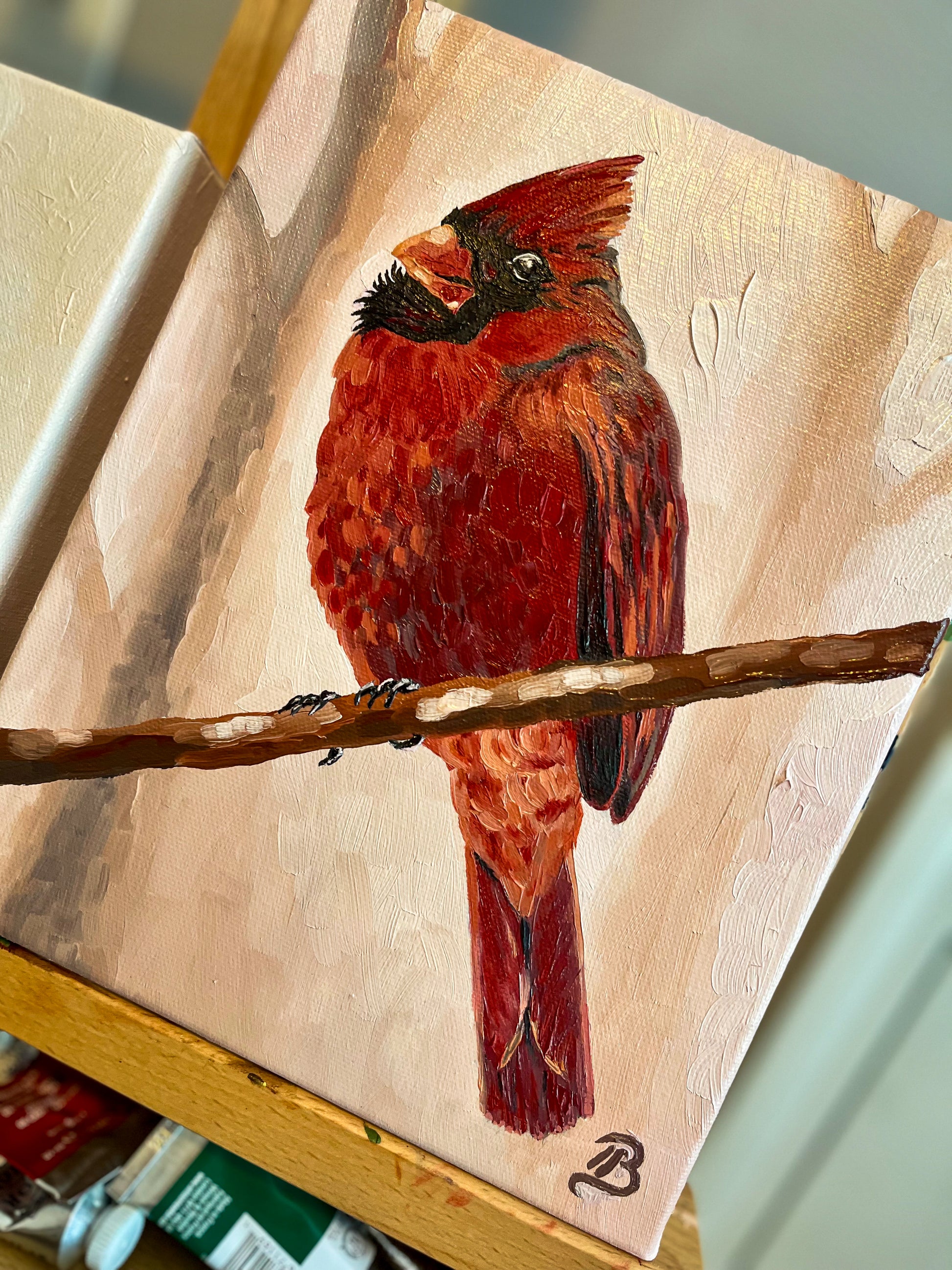 Red cardinal bird painting on a wooden easel