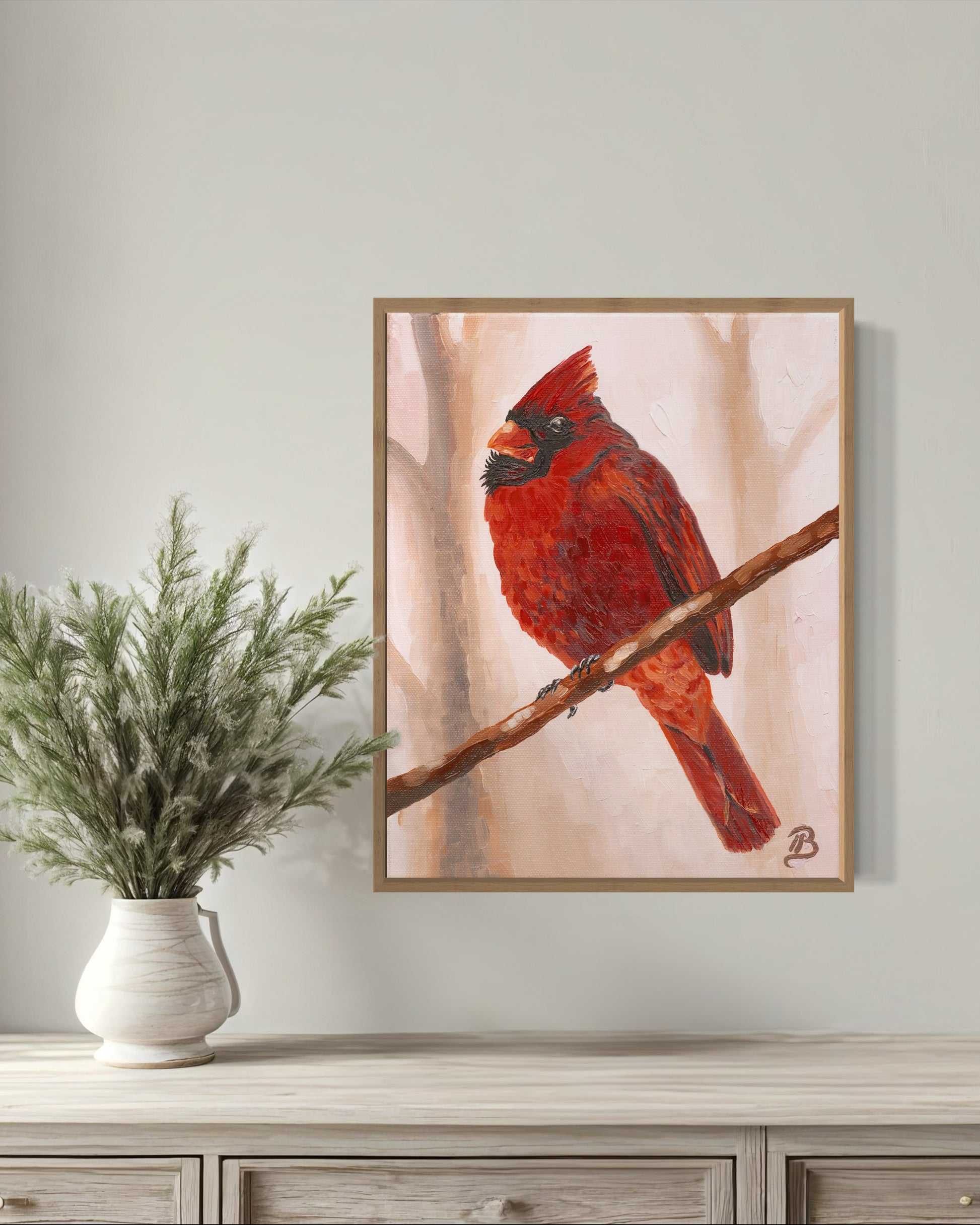 Framed fine art print of a red cardinal perched on a branch with a soft pink background and trees