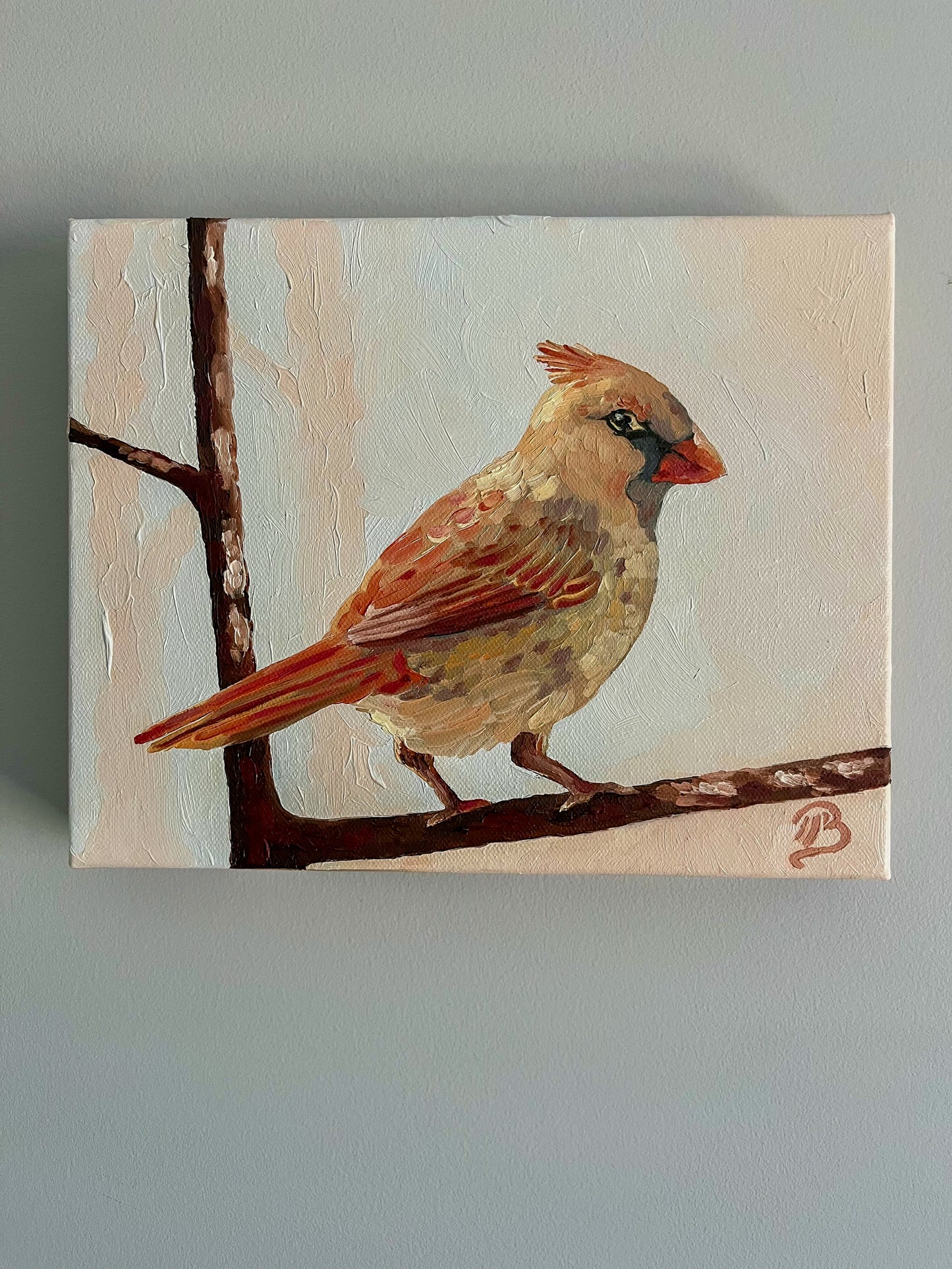 Painting of a female cardinal bird on a branch with a light background