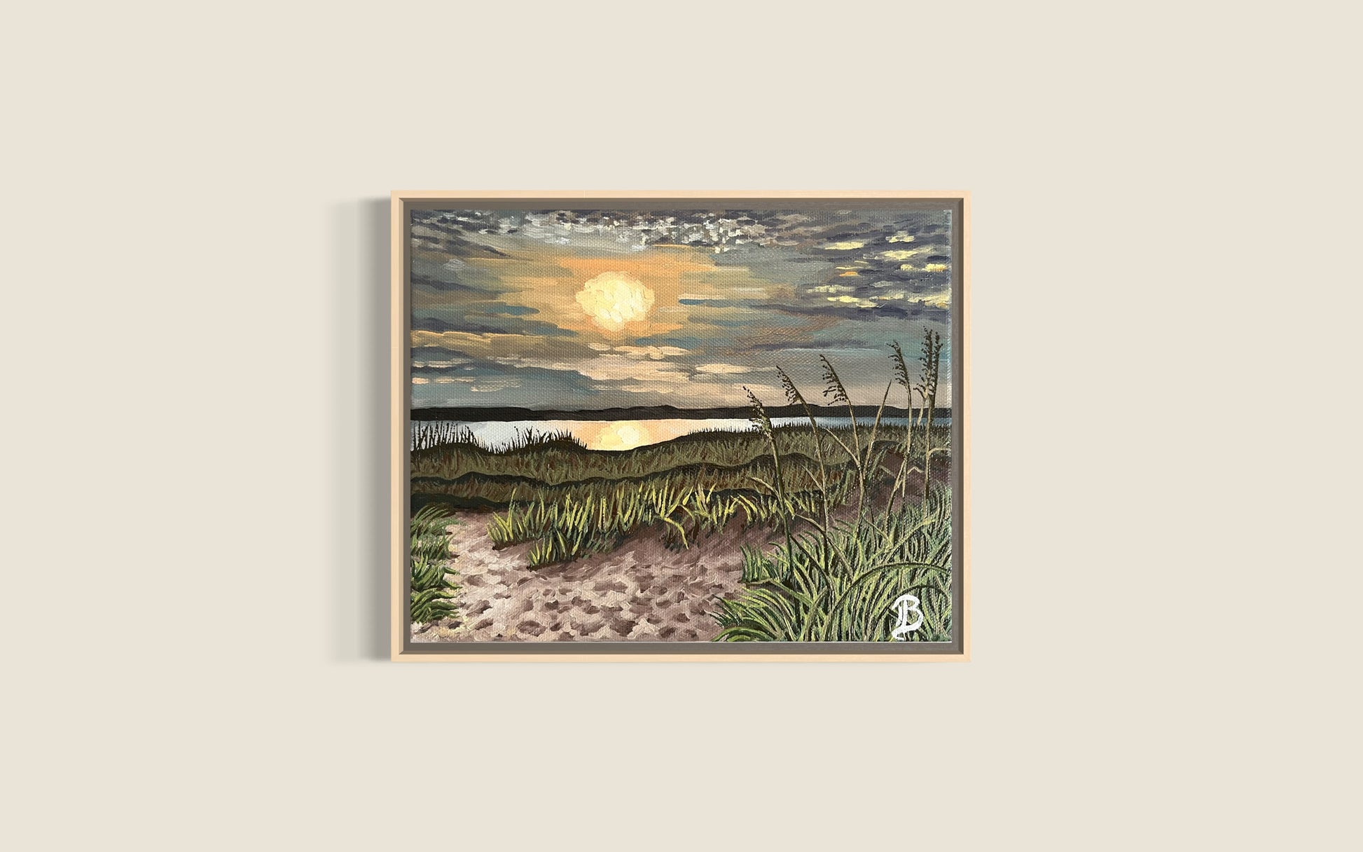 Framed artwork of a beach scene with sunset over water