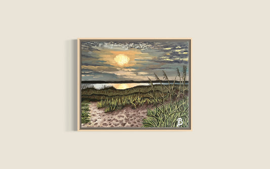 Framed artwork of a beach scene with sunset over water