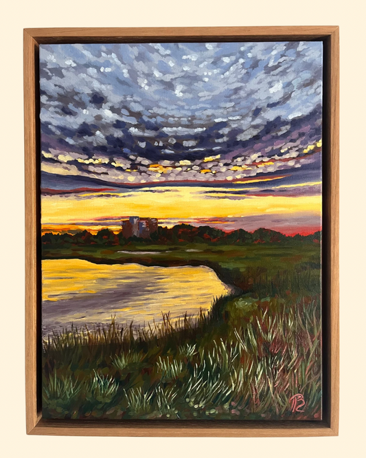 Painting of a sunset over the intracoastal waterway and marsh with building in distance.