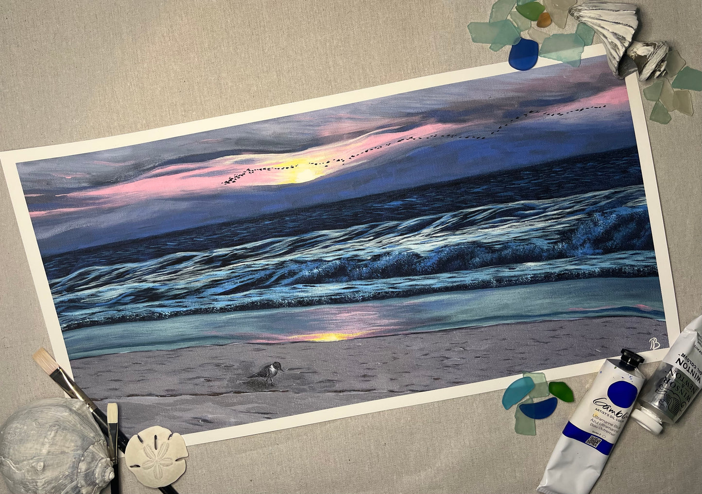 A fine art print of an acrylic on canvas painting featuring a sunrise at Wrightsville Beach with a serene beach scene.