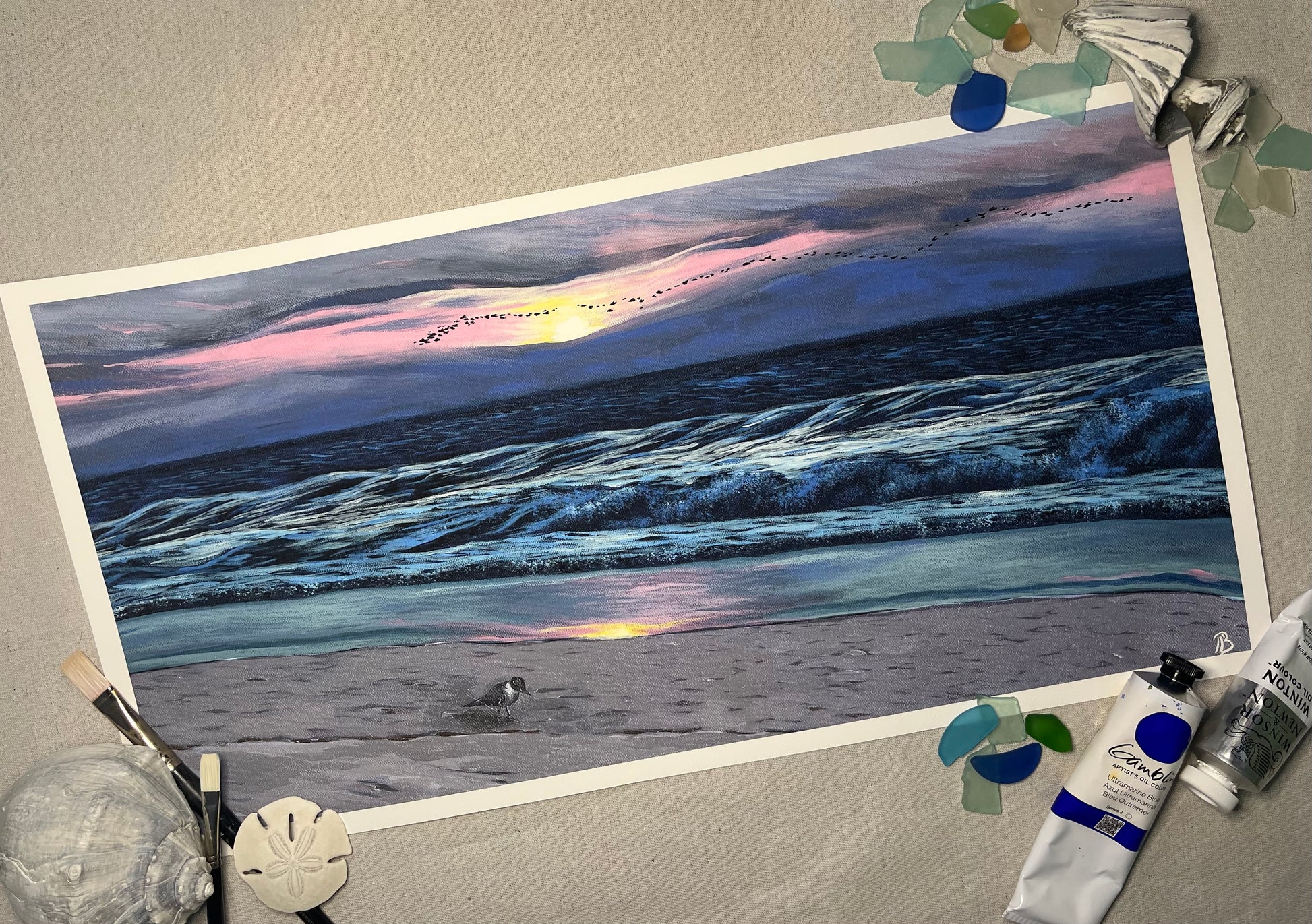 A fine art print of an acrylic on canvas painting featuring a sunrise at Wrightsville Beach with a serene beach scene.